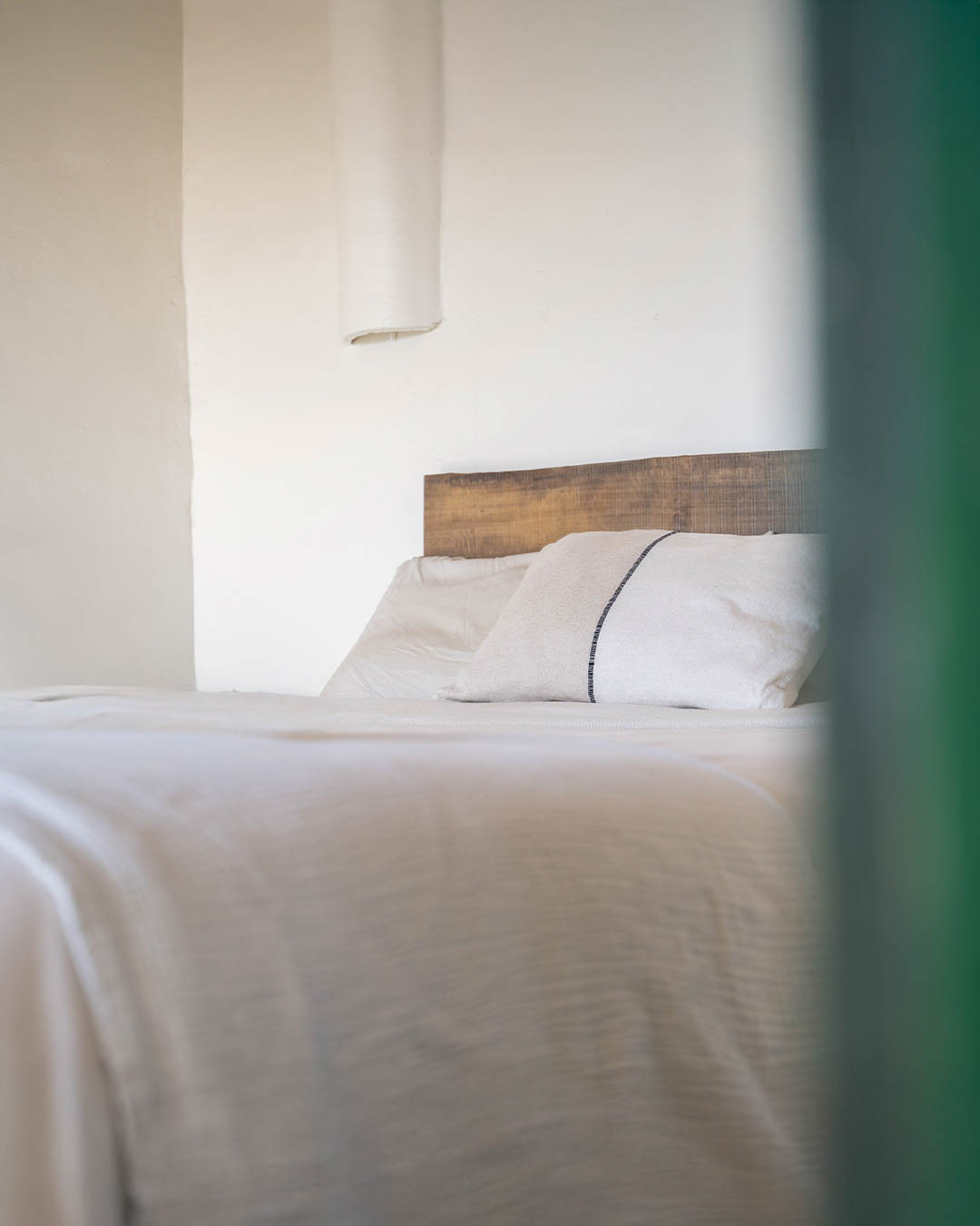 Camera da letto luminosa in villa mediterranea con dettagli autentici e minimalisti